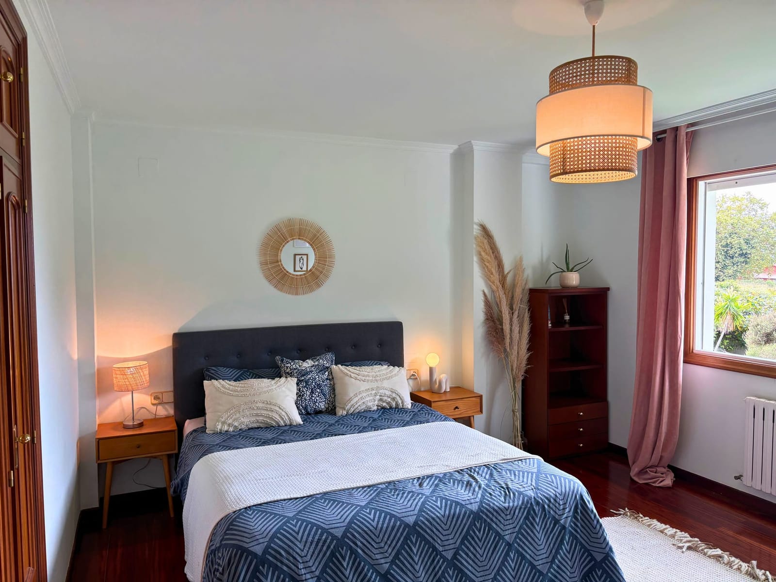 Master bedroom with upcycled furniture and warm light